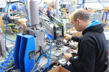 Un homme qui manipule une machine robotisée industrielle