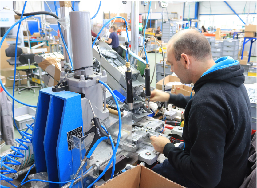 Un homme qui manipule une machine robotisée industrielle