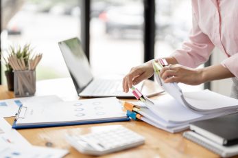 Personne qui cherche un document sur son bureau
