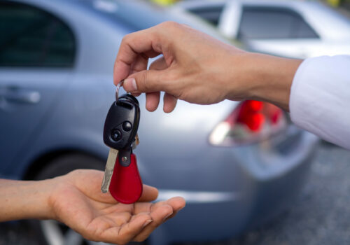 le vendeur de voiture donne les clés d'une voiture à un client